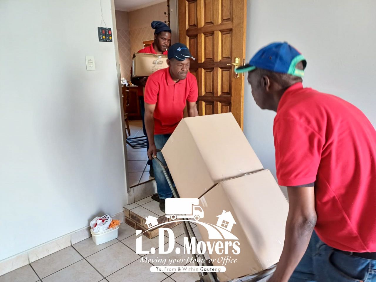 L.D. Movers crew carrying boxes through a home during a move